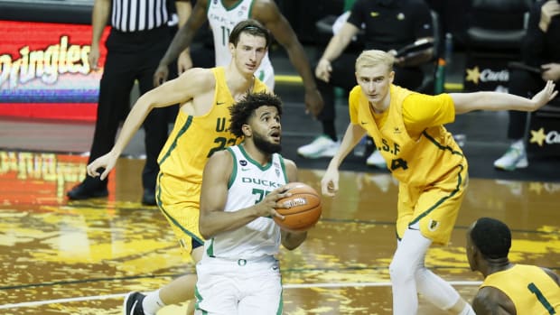 Dec 17, 2020; Eugene, Oregon, USA; Oregon Ducks guard LJ Figueroa (30) drives to the basket as San Francisco Dons forward Dzmitry Ryuny (22), Taavi Jurkatamm (34) and guard Jamaree Bouyea (1) look on during the second half at Matthew Knight Arena. Mandatory Credit: Soobum Im-USA TODAY Sports